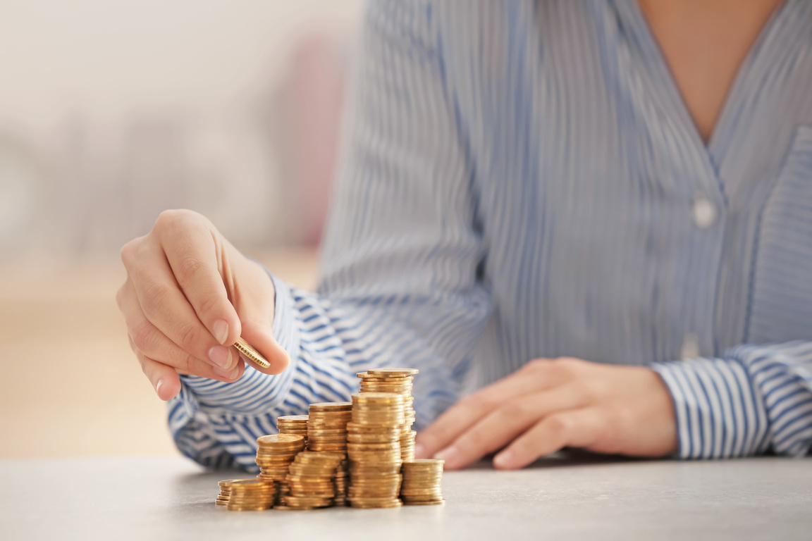 Woman Stacking Coins on Table
